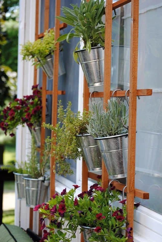 diy vertical garden with metal pots hung from a wooden frame