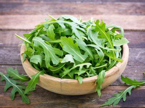 arugula leaves in a small wooden bowl