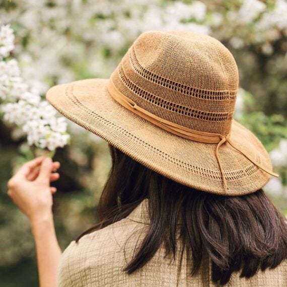 photo from behind of woman wearing straw sun hat