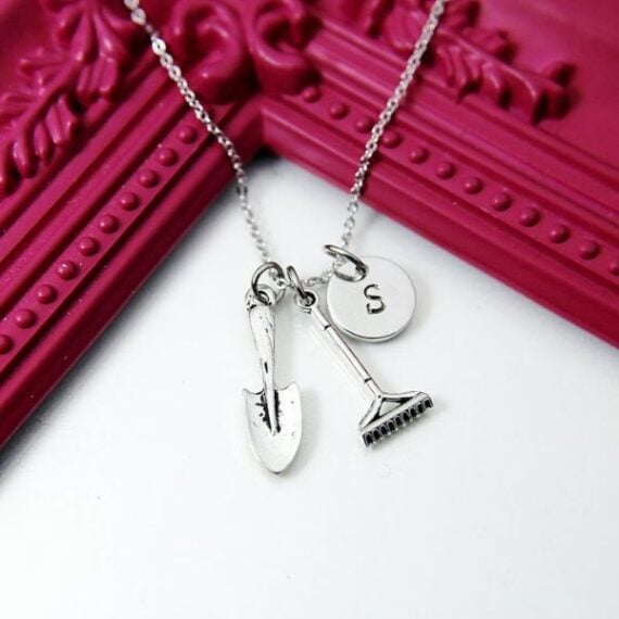 necklace with letter, spade, and rake charm as pendants